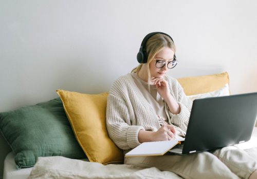 woman with laptop working on comfy couch